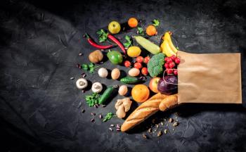 Healthy food in full paper bag of different products vegetables and fruits on dark background | Image Credit: © Storm - stock.adobe.com