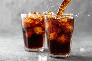 Pouring cola into glasses with ice cubes and visible fizz, ideal for refreshing drink advertisements and menu visuals. Generated with AI. | Image Credit: TommyNa - stock.adobe.com