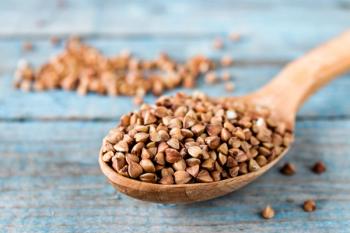 Uncooked buckwheat in a spoon on blue old boards. Buckwheat is used for cooking. | Image Credit: © Maryna Osadcha - stock.adobe.com