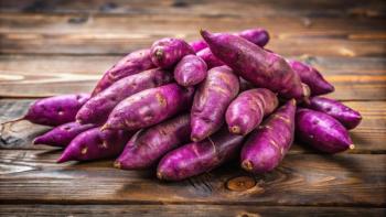 Extreme close-up of heap of raw purple sweet potatoes on wooden background. Generated with AI. Image Credit: © suchetpong - stock.adobe.com.
