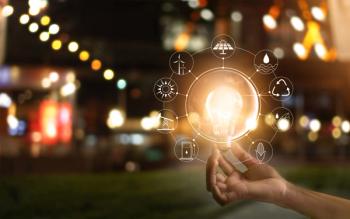 Hand holding lightbulb in front of global, show the world's consumption with icons energy sources. Energy concept. | Image Credit: © ipopba - stock.adobe.com