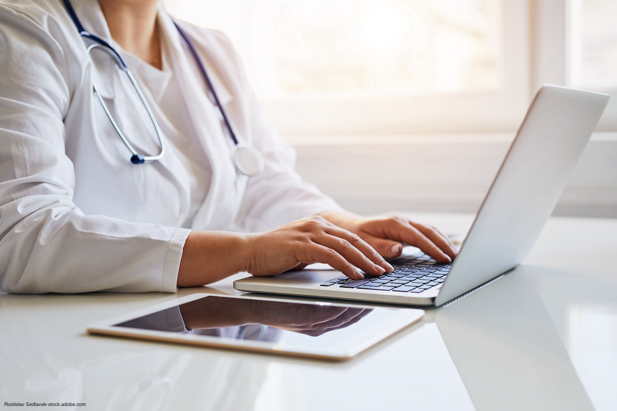 doctor typing on laptop