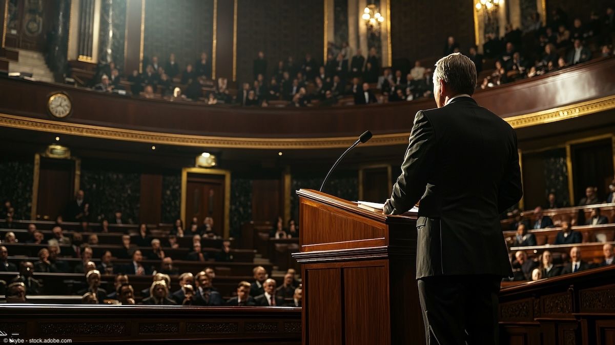 Lawmaker stands at podium | Image Credit: © ckybe - stock.adobe.com
