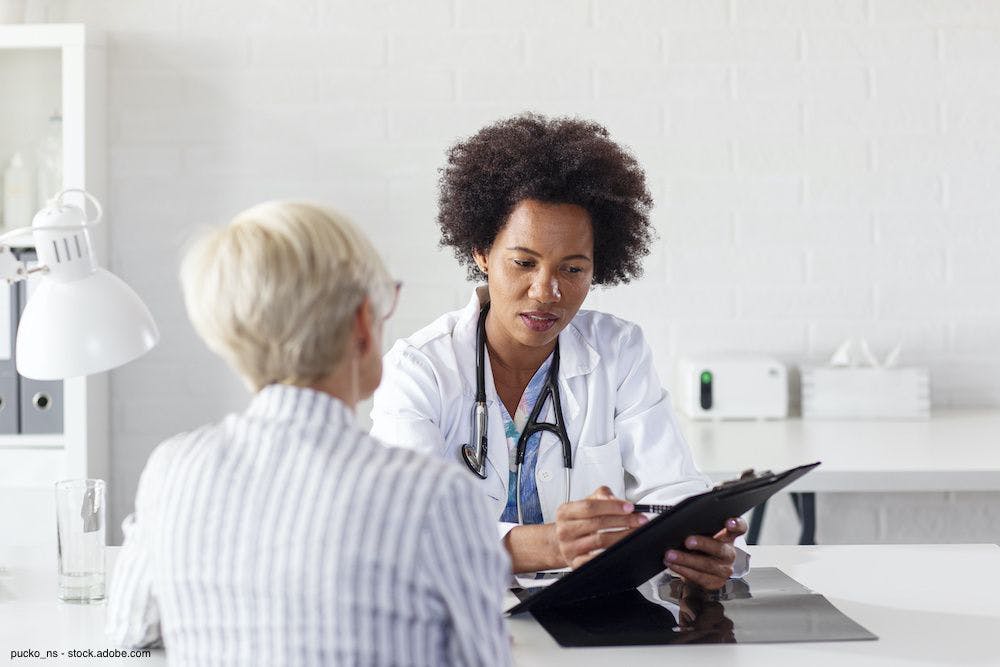 female doctor facing and talking to a female patient
