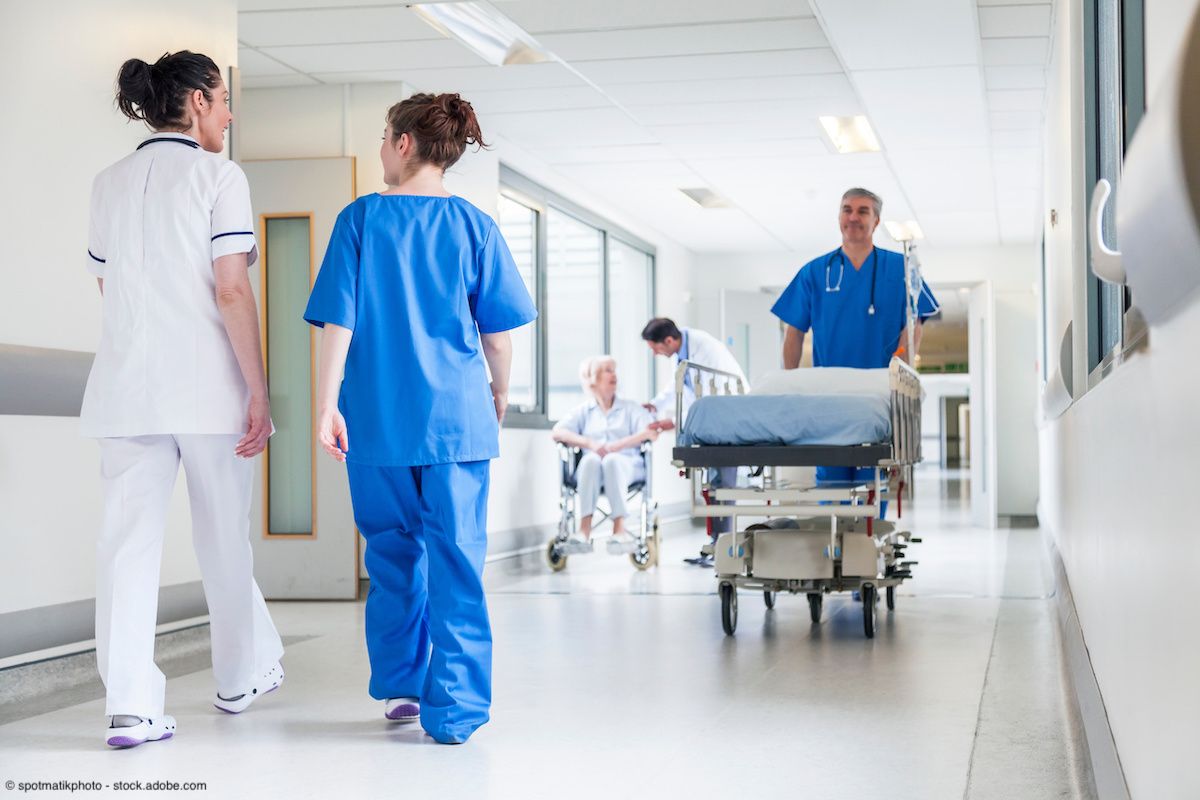Male nurse pushing stretcher gurney bed in hospital corridor with doctors & senior female patient | Image Credit: © spotmatikphoto - stock.adobe.com 