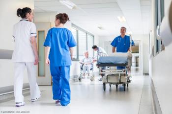 Male nurse pushing stretcher gurney bed in hospital corridor with doctors & senior female patient | Image Credit: © spotmatikphoto - stock.adobe.com 