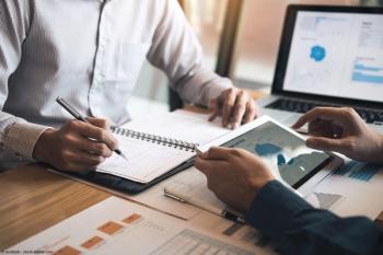 Two business partnership coworkers discussing a financial planning graph and company during a budget meeting in office room. | Image Credit: © wutzkoh - stock.adobe.com