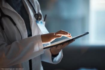 Telehealth, digital tablet and doctor hands for hospital innovation, software management and results update in dark workplace. Healthcare, cardiology and telecom medical professional with technology | Image Credit: © Rene L/peopleimages.com - stock.adobe.com