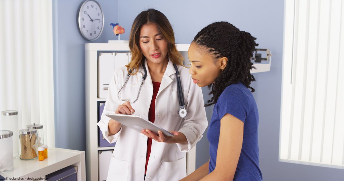 African American patient explaining issues to Asian doctor using tablet | Image Credit © rocketclips - stock.adobe.com