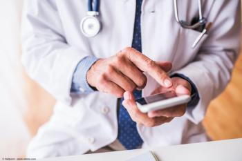 Doctor using smartphone | Image Credit: © Halfpoint - stock.adobe.com