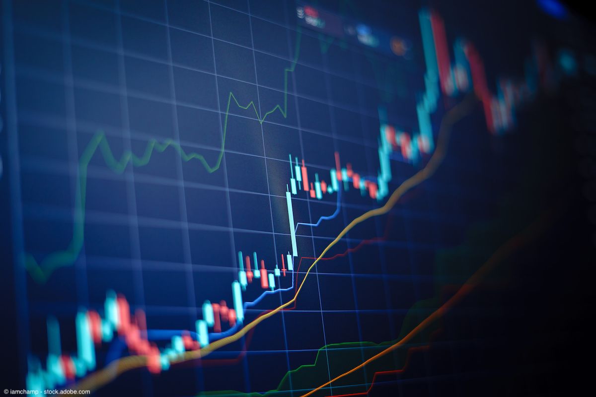 Closeup financial chart with uptrend line candlestick graph in stock market on blue color monitor background | Image Credit: © iamchamp - stock.adobe.com