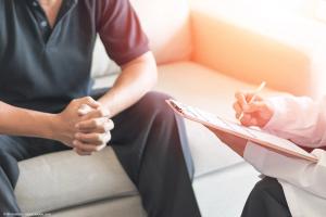 Man talking with a doctor, who is taking notes on a clipboard | Image Credit: © Khunatorn - stock.adobe.com