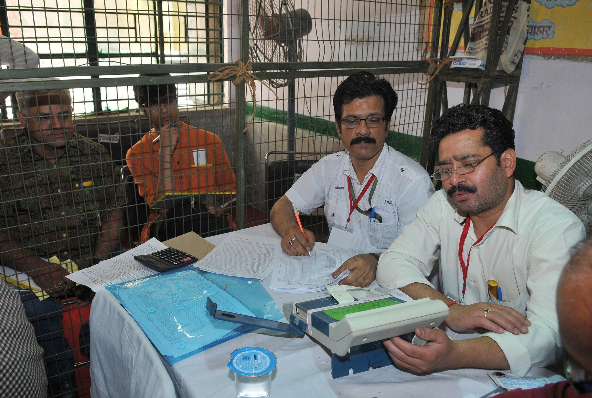 Election officials read results from an electronic voting machine at a counting centre in New Delhi