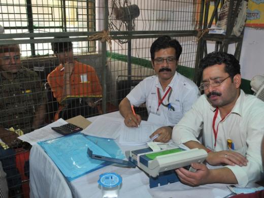Election officials read results from an electronic voting machine at a counting centre in New Delhi