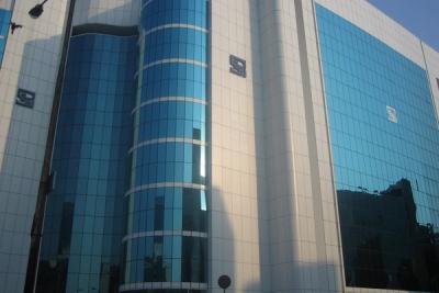 Glass-clad SEBI Bhavan office tower in Mumbai, with blue-tinted windows and the SEBI logo on its facade, in daylight.