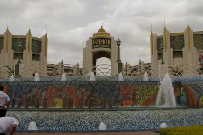 Ornate entrance gate of Ramoji Film City with fountains and mosaic 'Movie Magic' lettering under a cloudy sky.