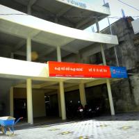 Exterior of an IDBI Bank branch with red and white signage, with motorbikes parked under a concrete building.