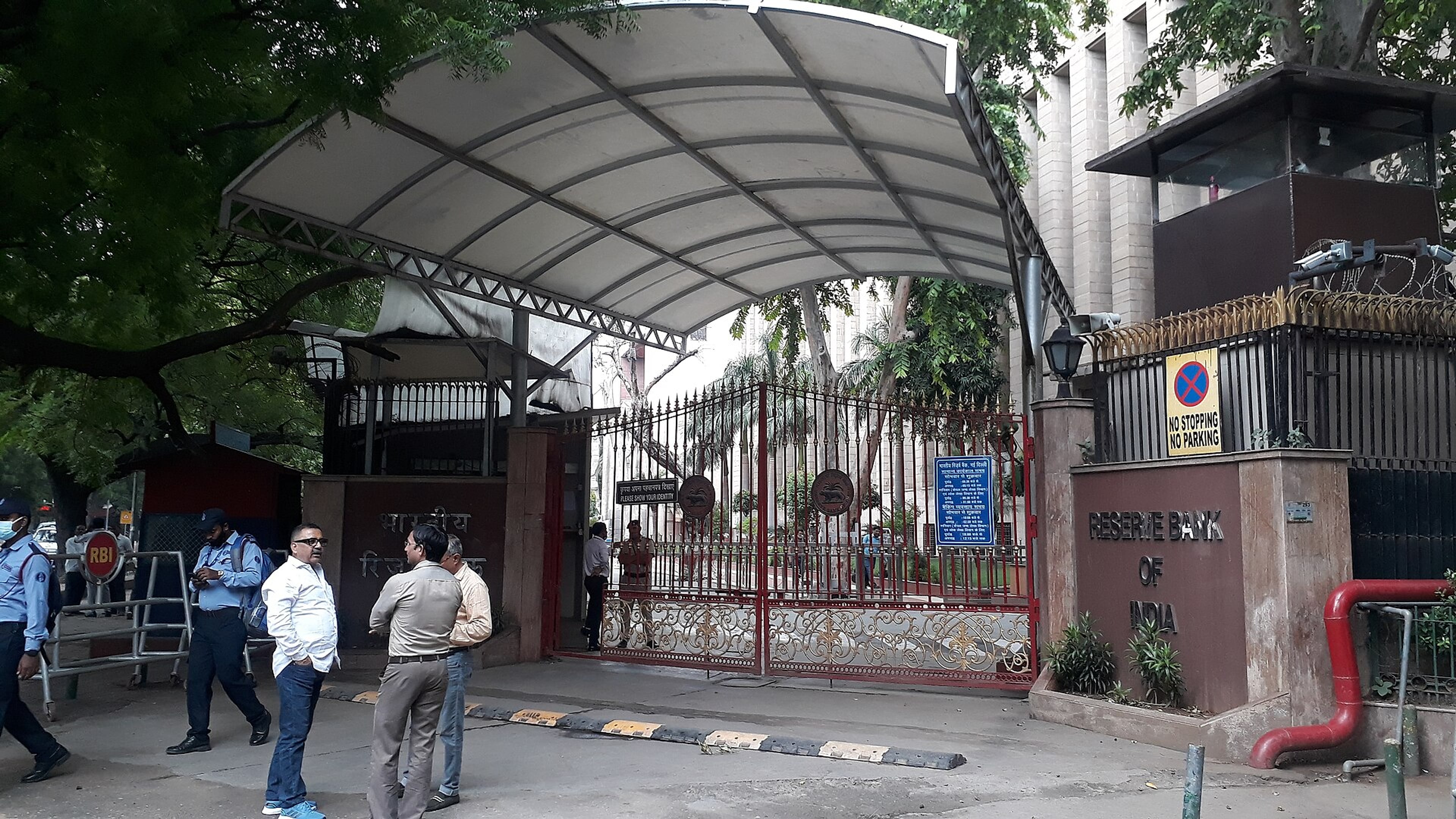 Reserve Bank of India building in New Delhi, with motorbikes and auto-rickshaws moving on the road in front.