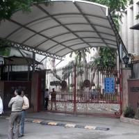 Reserve Bank of India building in New Delhi, with motorbikes and auto-rickshaws moving on the road in front.