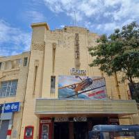 Facade of the Regal cinema building with a film poster on its upper wall and a police van at the entrance.