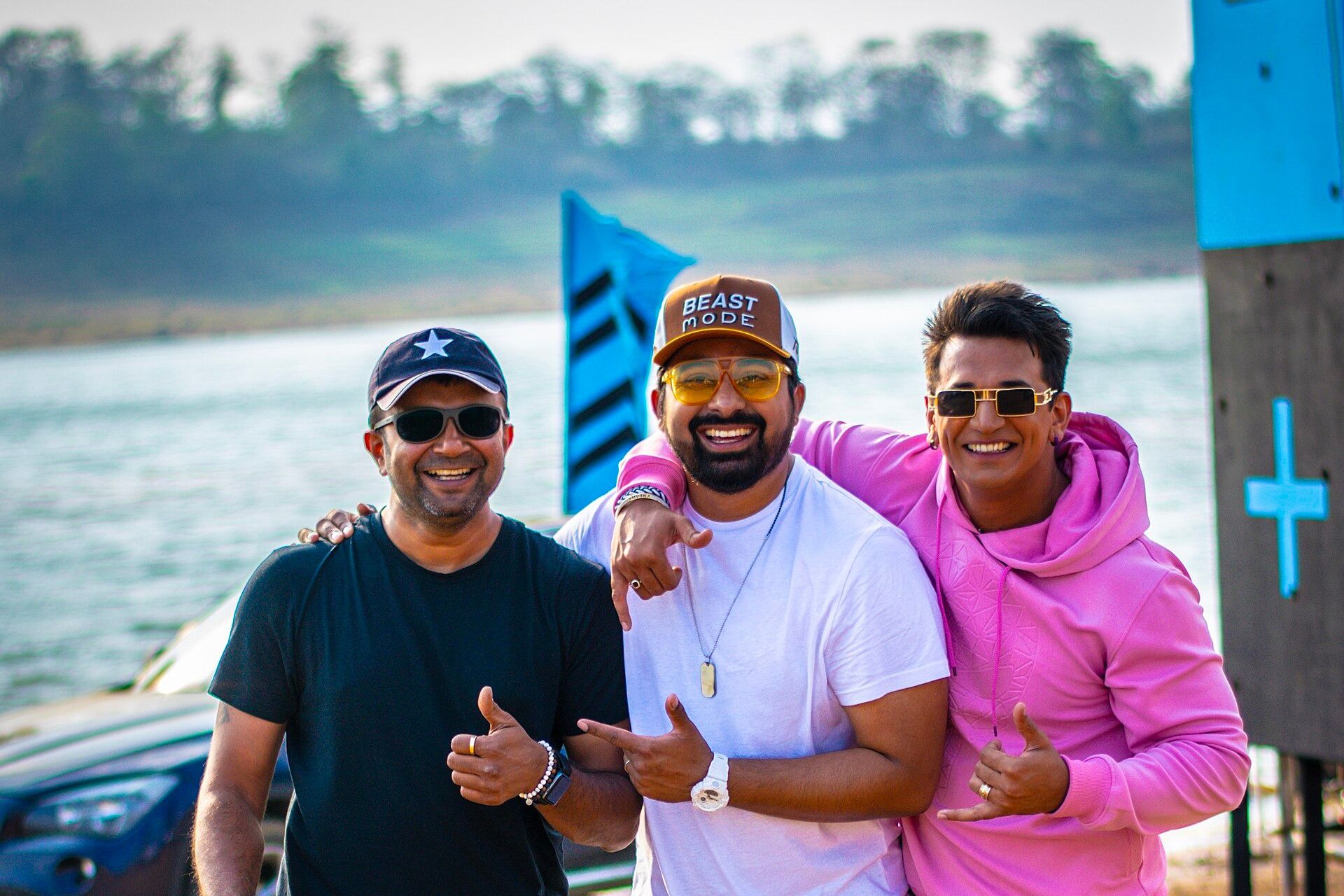 Rannvijay Singha in a cap and white T-shirt with Prince Narula in a pink hoodie and photographer Ashish Parmar, beside a lake