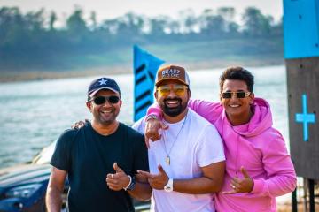 Rannvijay Singha in a cap and white T-shirt with Prince Narula in a pink hoodie and photographer Ashish Parmar, beside a lake