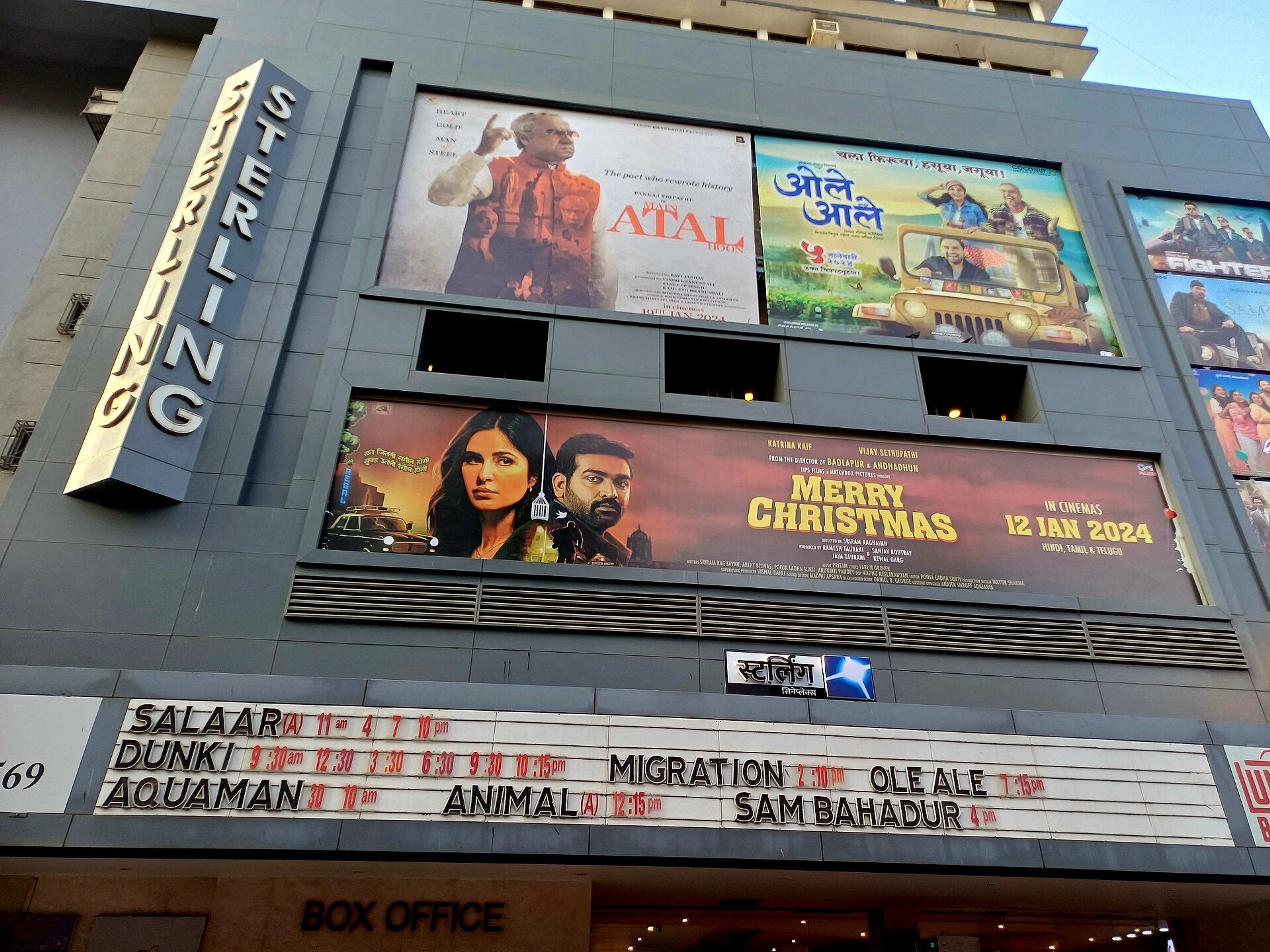 Cinema front with a vertical Sterling sign, film posters, a showtimes board and a box office sign
