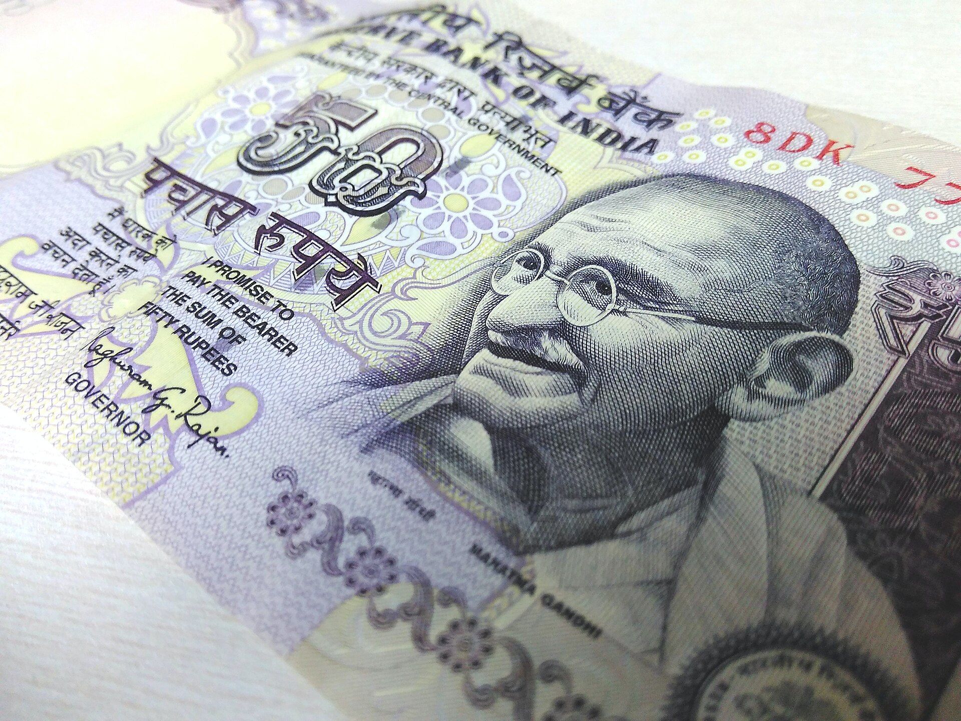 Close-up of a 50-rupee Indian banknote lying at an angle on a light surface