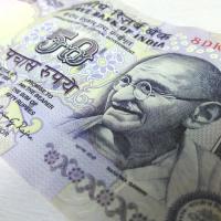 Close-up of a 50-rupee Indian banknote lying at an angle on a light surface