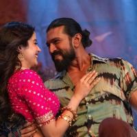 Janhvi Kapoor, in a pink blouse and gold jewellery, and Ram Charan, in a tie-dye shirt, smile at each other in a song from Peddi