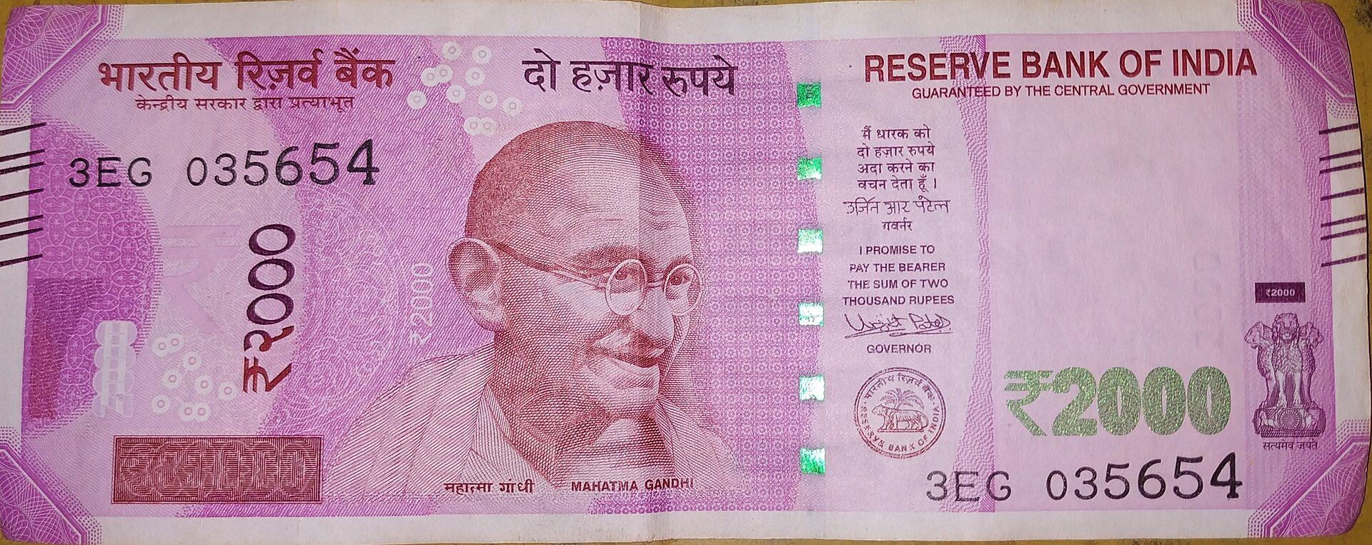 Front of a ₹2000 Indian banknote in pink-violet with a portrait, Reserve Bank of India text and a green ₹2000 numeral