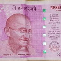Front of a ₹2000 Indian banknote in pink-violet with a portrait, Reserve Bank of India text and a green ₹2000 numeral