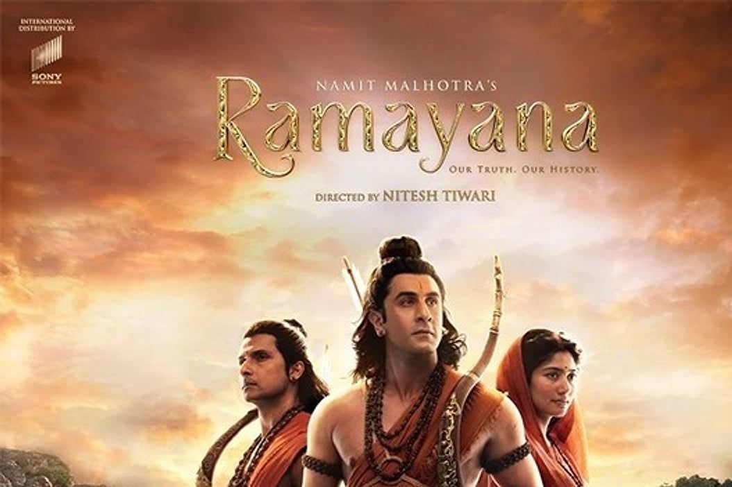 Official poster for Ramayana showing three figures in saffron costumes against a rocky landscape at sunset