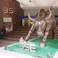 Bronze bull statue on a green mat at the foot of a stone staircase, with BSE lettering on the wall behind