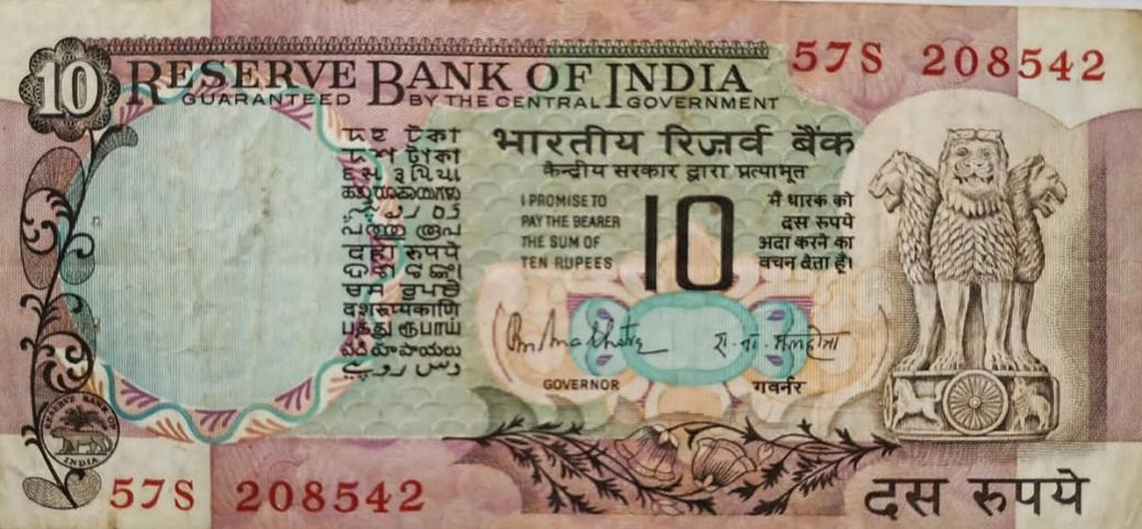 Close view of an Indian ten rupee banknote with Reserve Bank of India text and the Ashoka lion capital emblem.