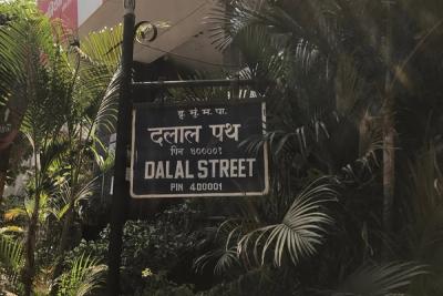 Blue Dalal Street sign in Hindi and English, with palm trees behind it.