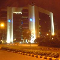 Night view of the SEBI building in Bandra Kurla Complex, its arched concrete frame lit against a dark sky.