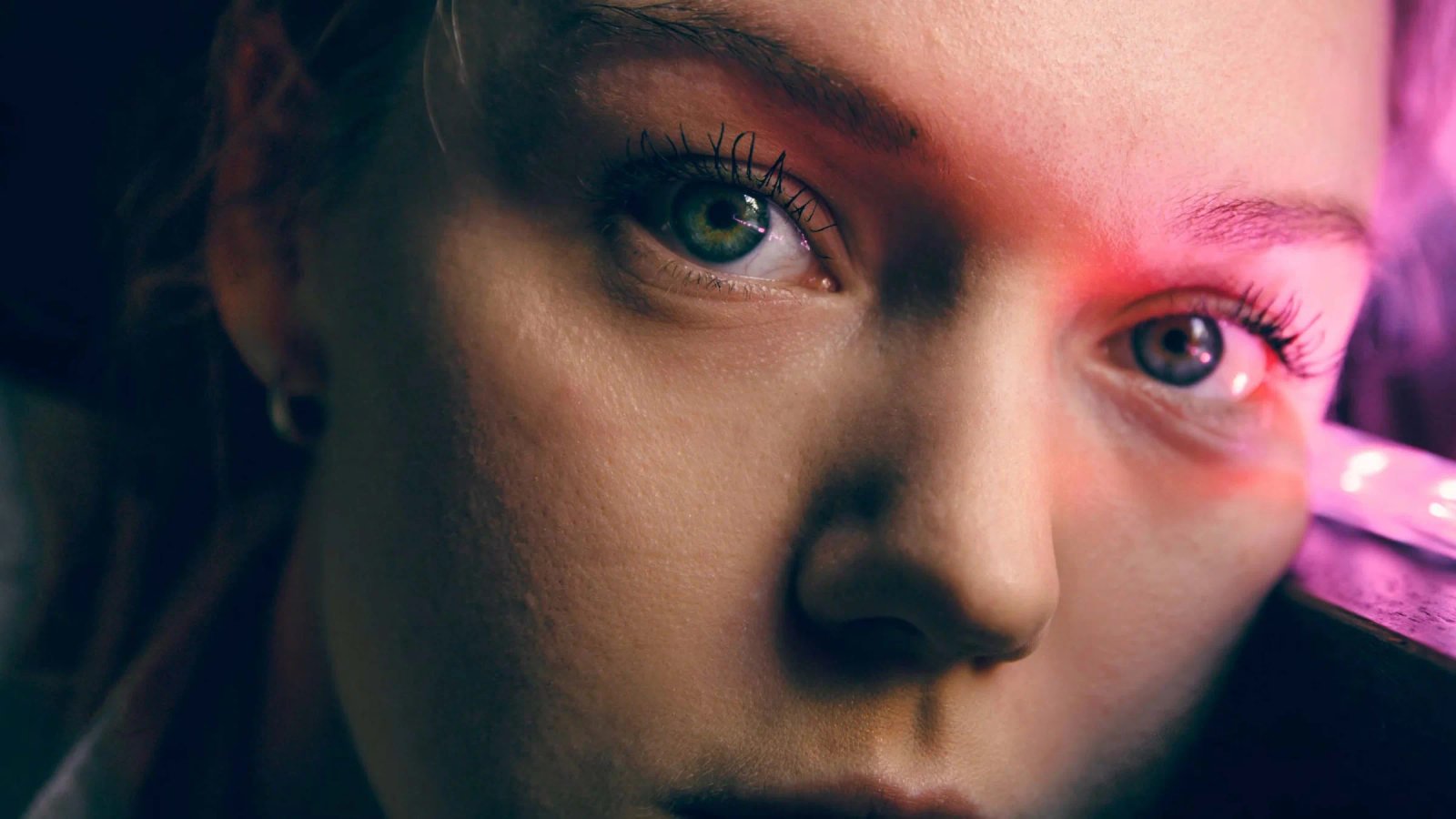 Portada de Consumer Trends 2026: primer plano del rostro de una mujer, con una luz rosa sobre un ojo.