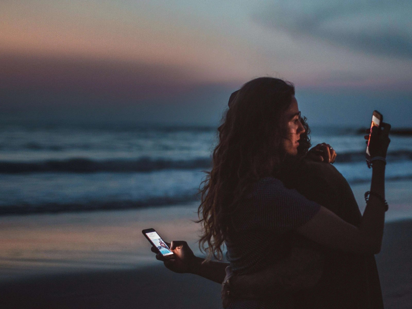 Consumer Trends 2023 cover: two people hug on the beach at dusk, each looking at their own phone.