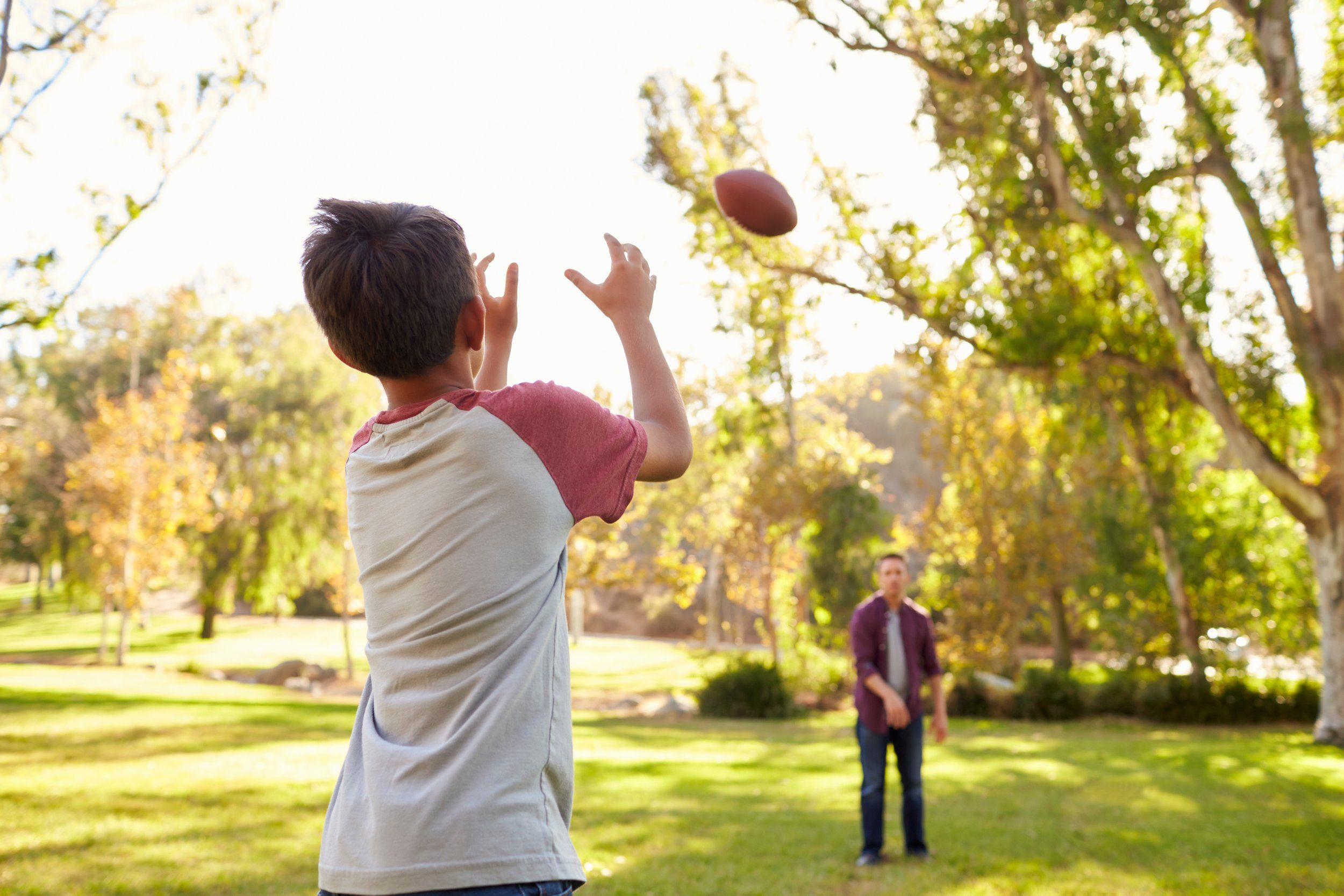 Dad throwing a football with a child