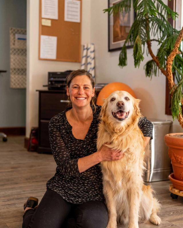 Erin Downey with her golden retriever in the West Bank Physical Therapy clinic