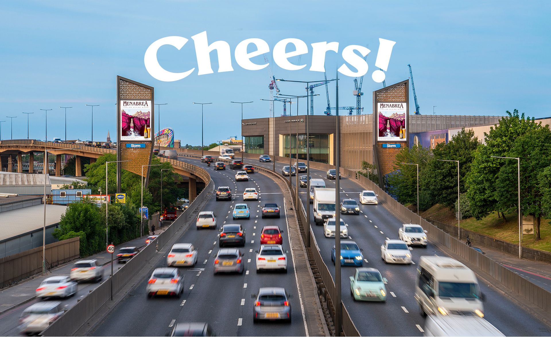 Two bilboards across a busy road saying 'cheers'