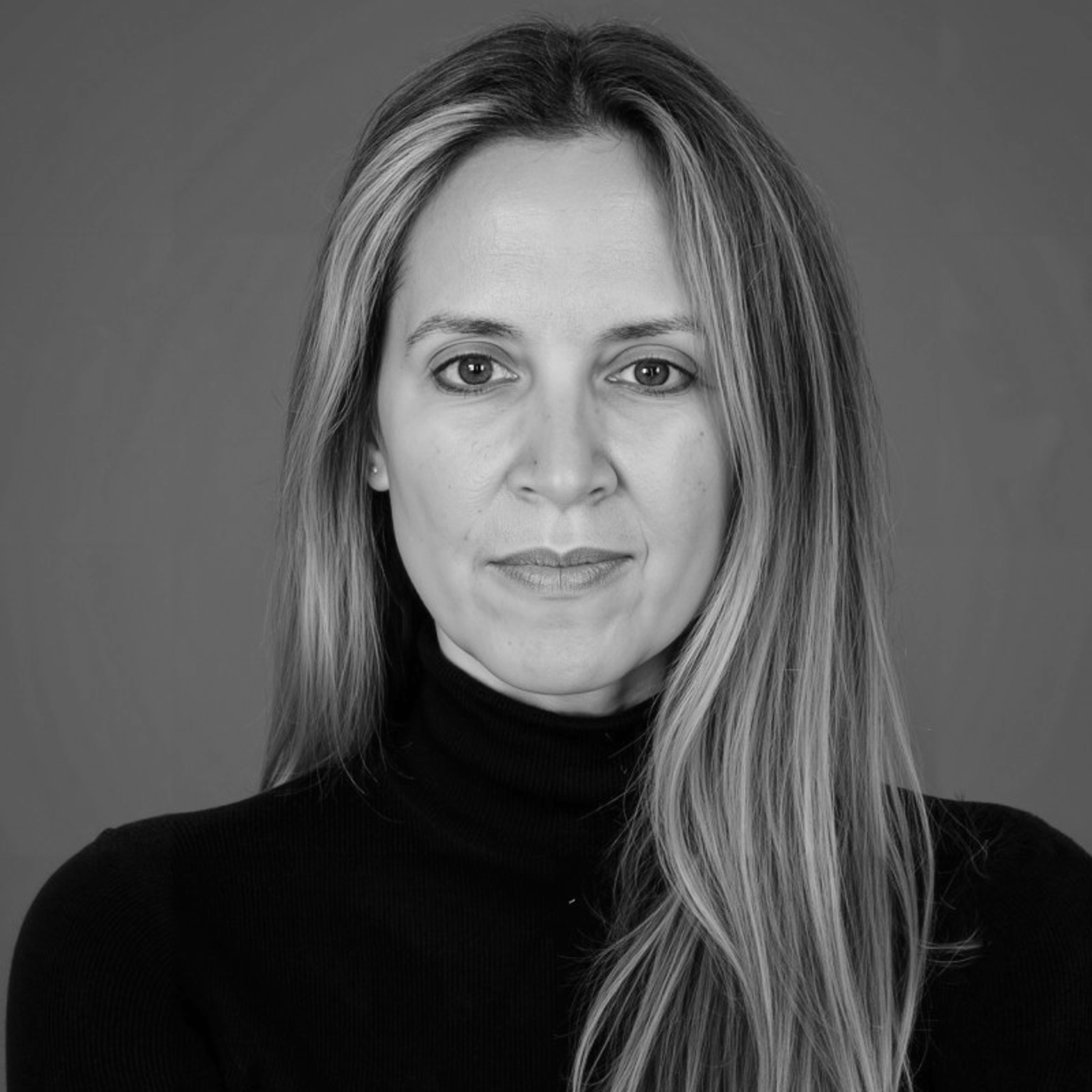 Black and white portrait of a woman with long hair wearing a black turtleneck.