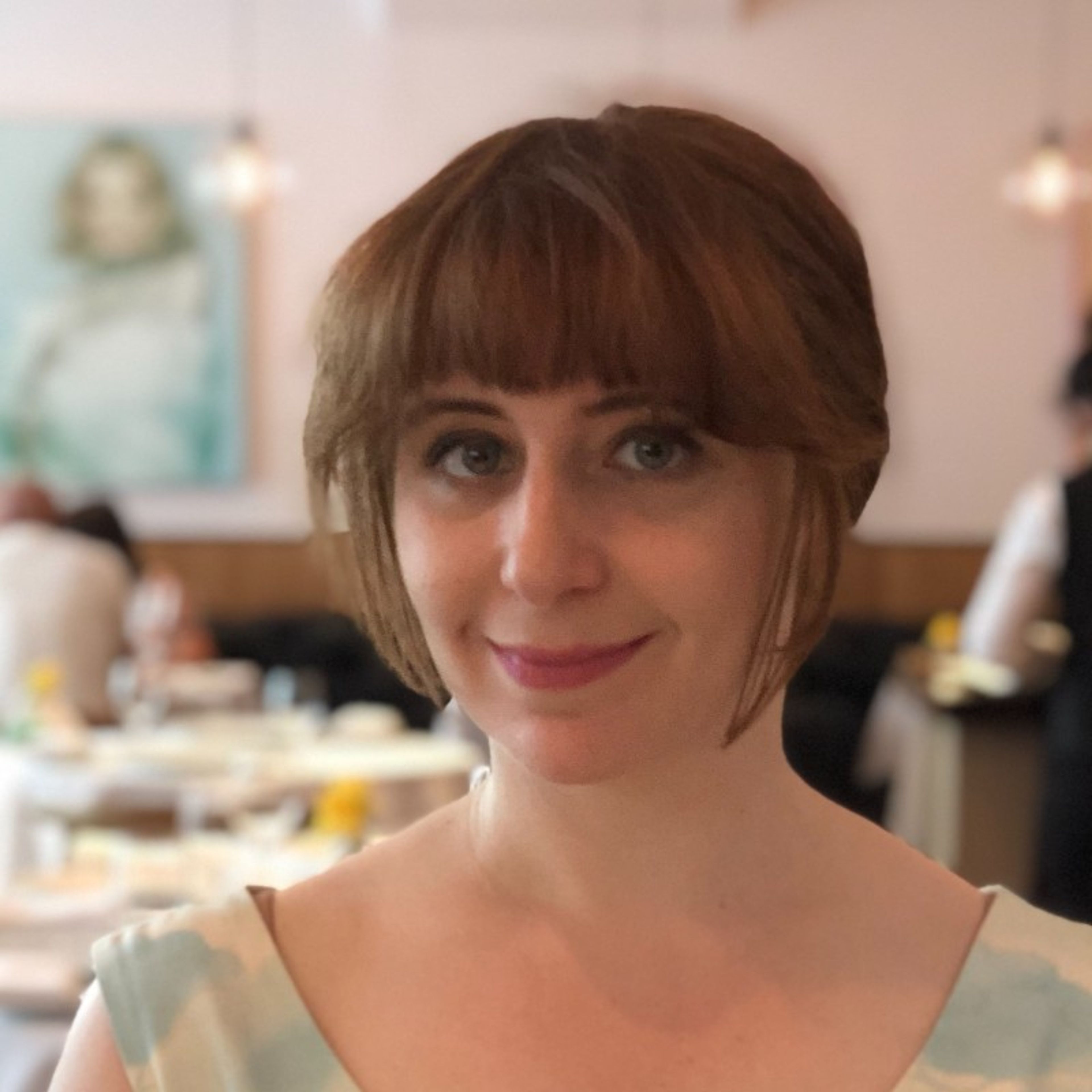 A smiling woman with short reddish-brown hair and bangs.