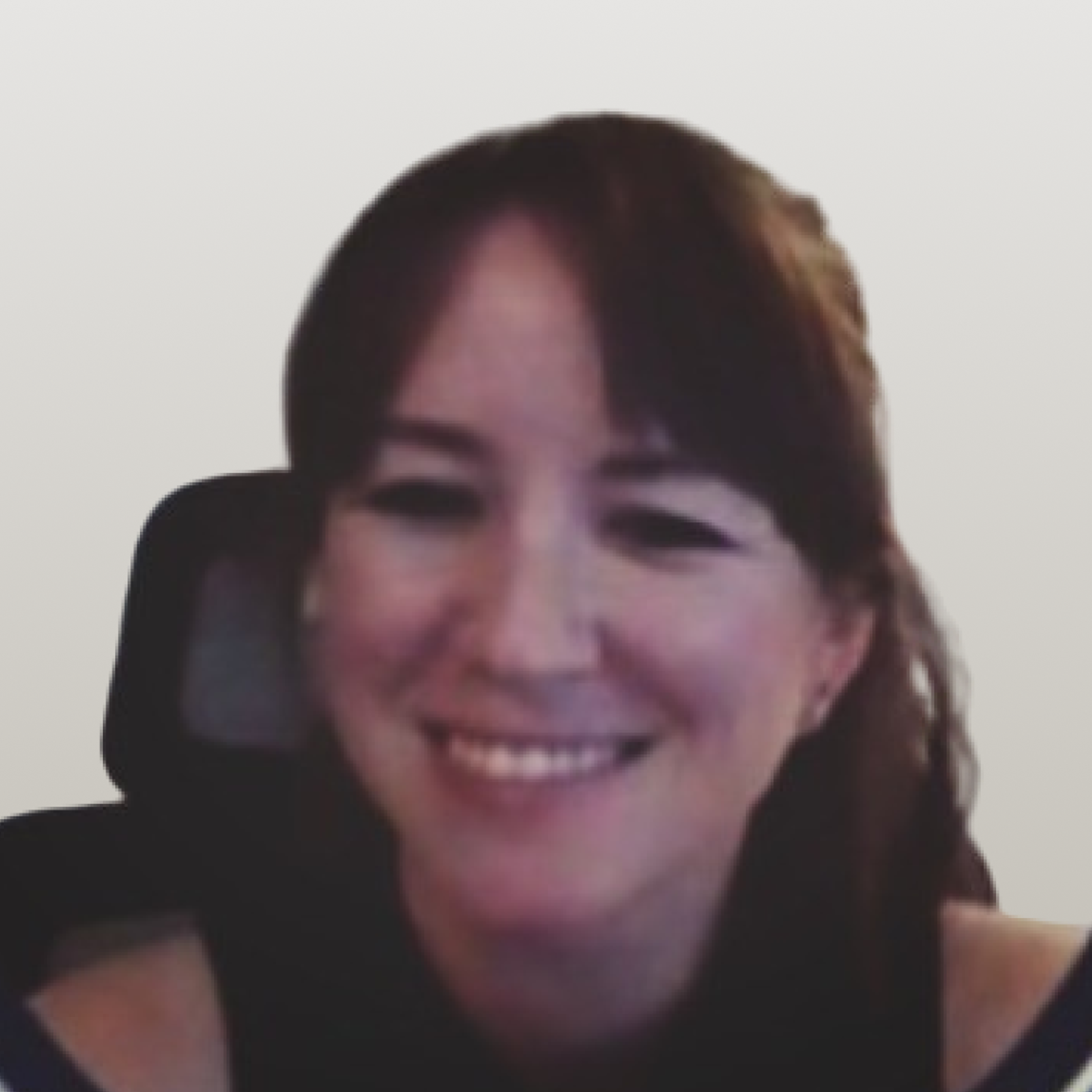 A smiling woman with dark hair and bangs looks towards the camera.