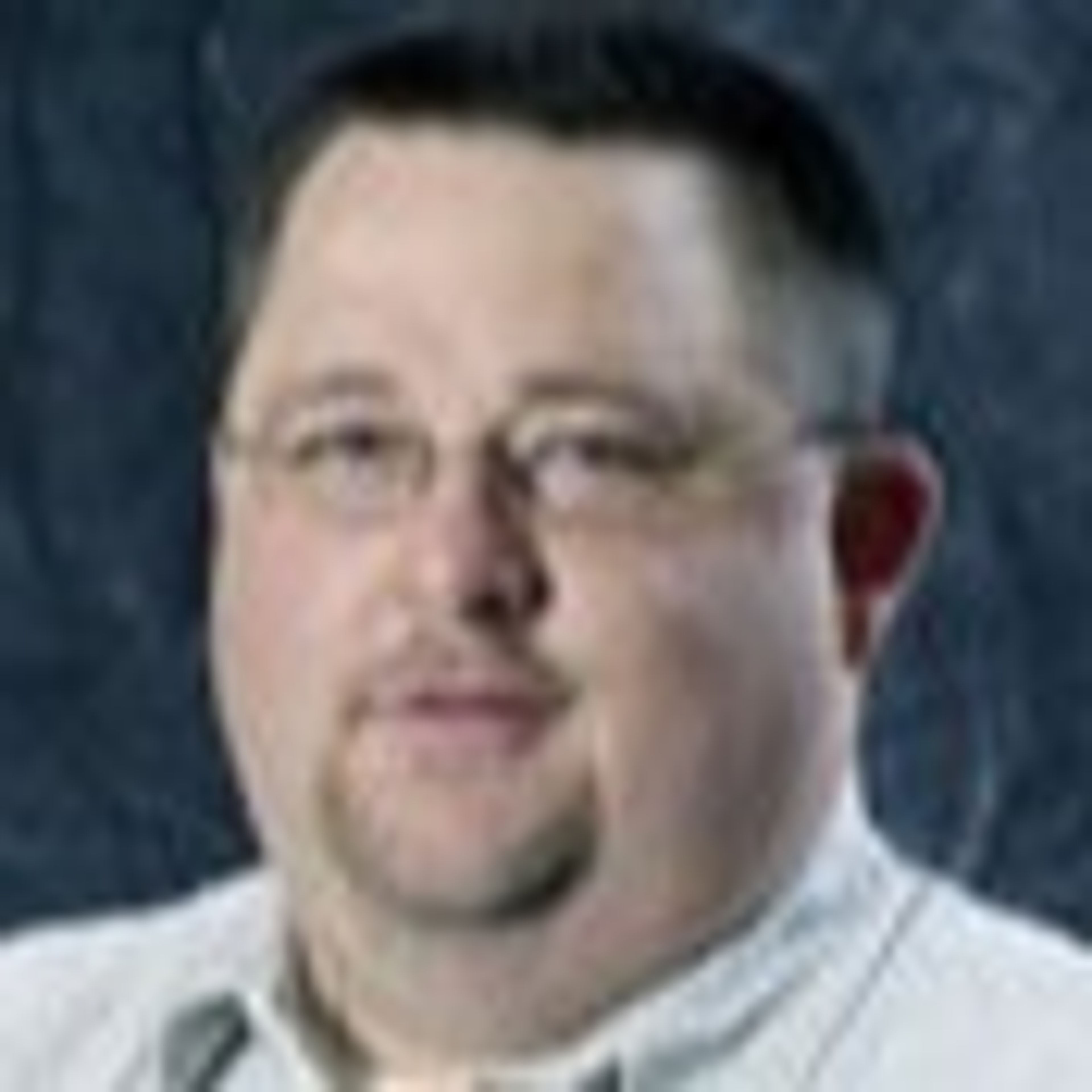Headshot of a man with glasses and a goatee.
