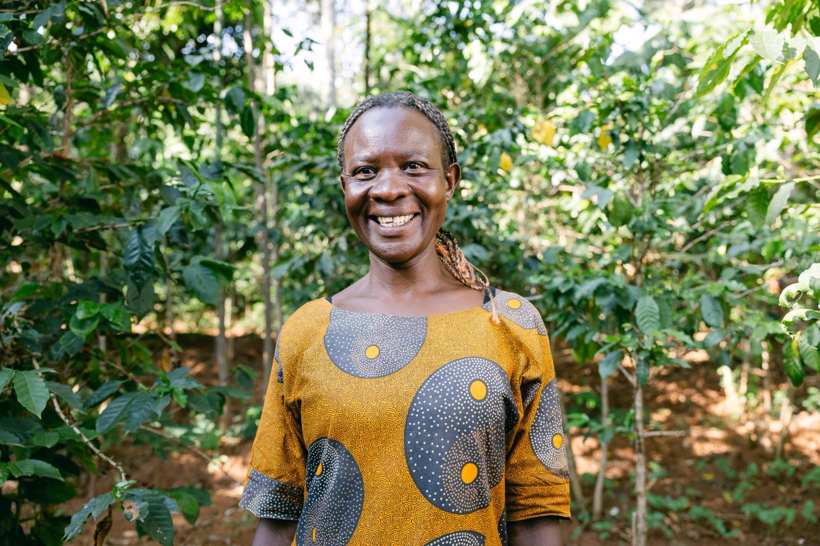 A farmer smiling in front of her crops