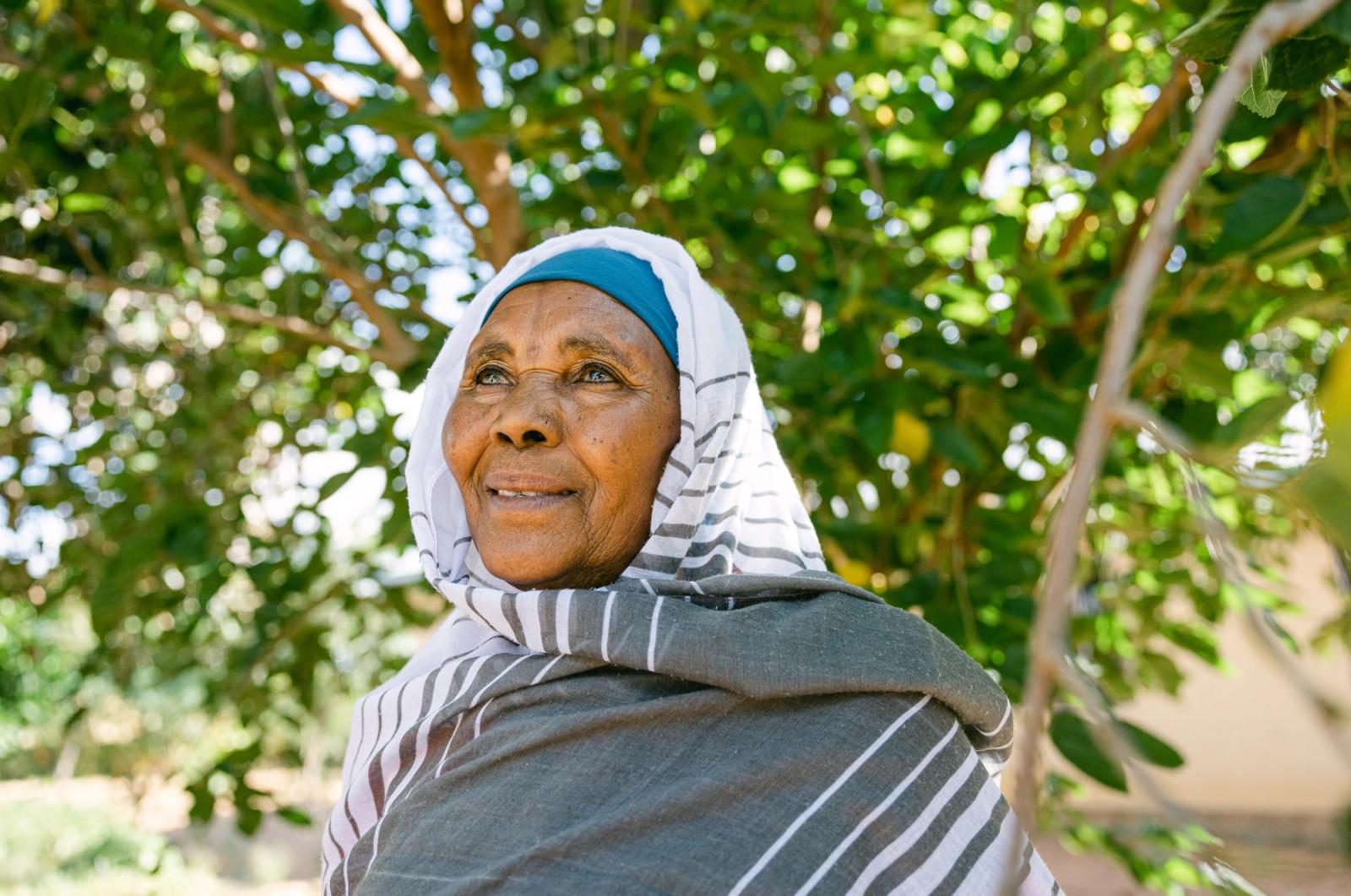 A farmer standing among her trees