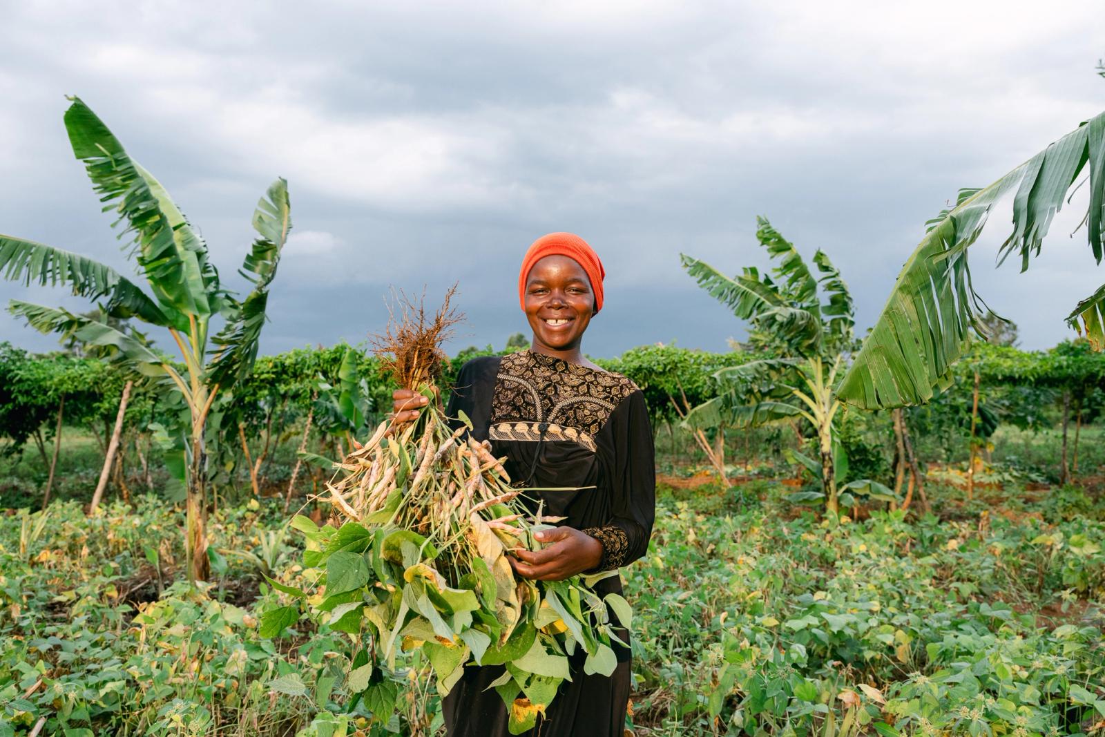A smiling farmer holding a freshly harvested crop
