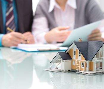 Signing VA loan offer with a house concept in table.